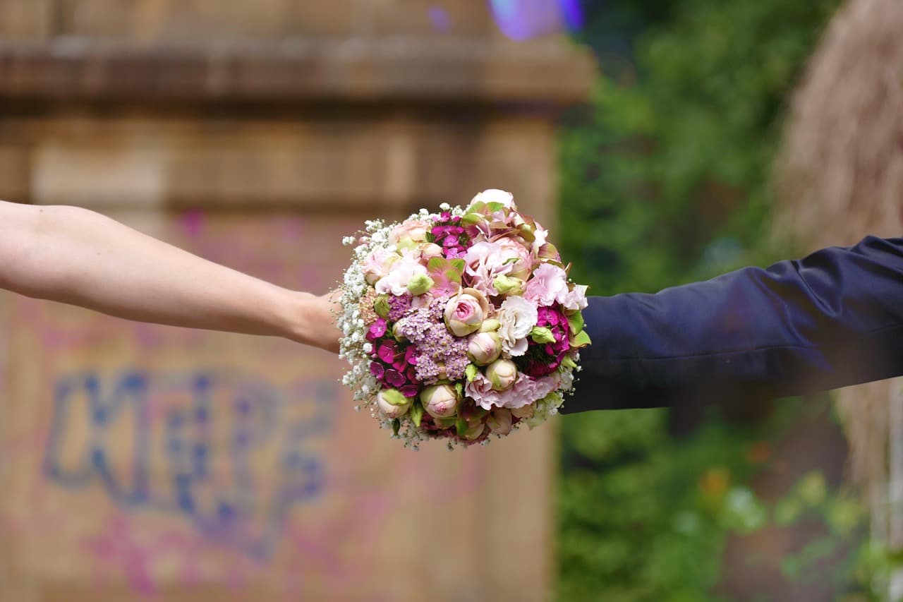 Hafsa's hands carefully arranging flowers at the Bloom & Beyond studio in Lahore