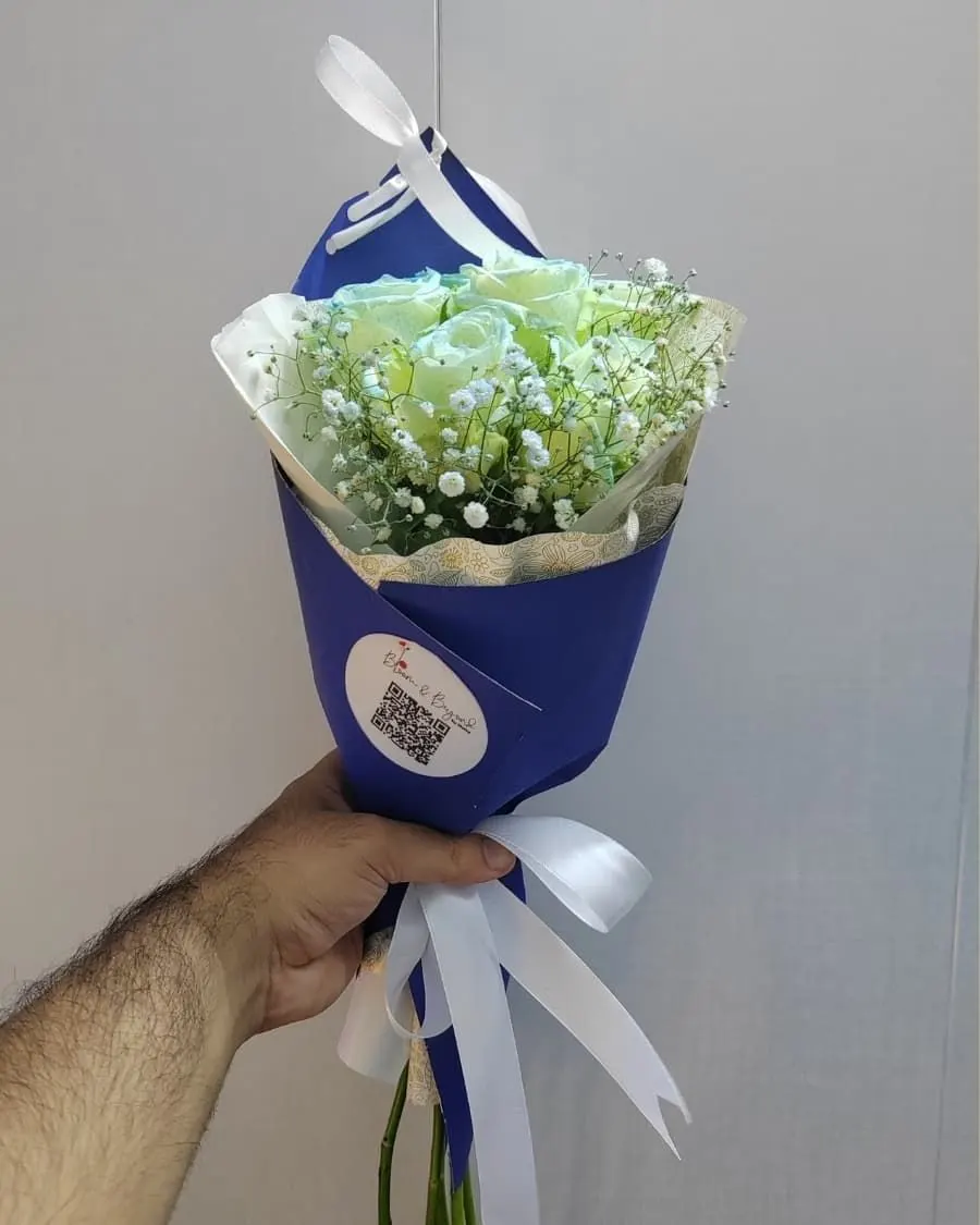 Rare tinted blue roses with baby breath in navy blue wrapping — a unique and memorable gift — handcrafted by Bloom & Beyond in Lahore