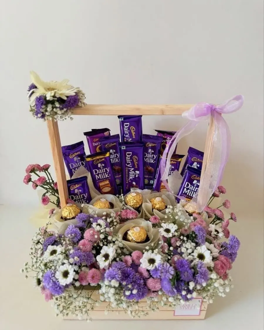 The best of both worlds — Cadbury Dairy Milk, Ferrero Rocher, and mixed fresh flowers arranged in a rustic wooden crate — handcrafted by Bloom & Beyond in Lahore
