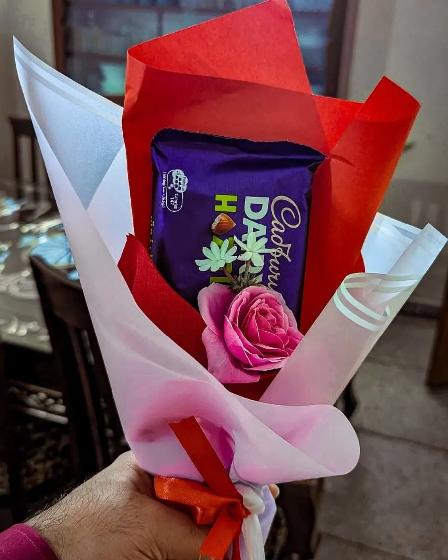 Chocolate and rose mini bouquet — a Cadbury Dairy Milk bar wrapped with a single fresh rose — handcrafted by Bloom & Beyond in Lahore