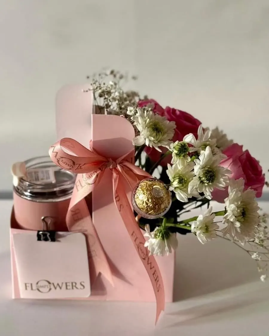 A beautiful carrier box with fresh roses, daisies, a scented candle, and Ferrero Rocher chocolates — handcrafted by Bloom & Beyond in Lahore