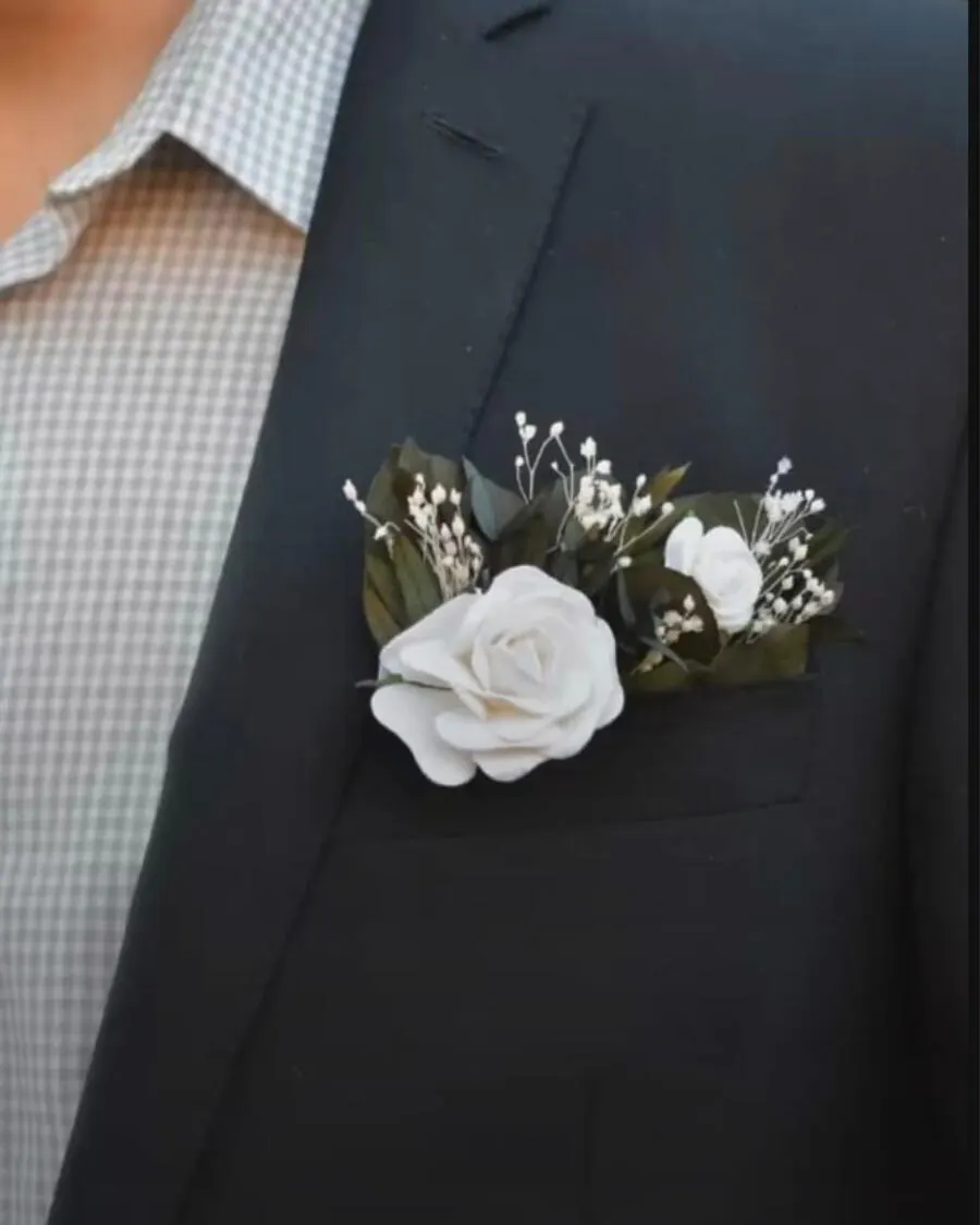 A boutonniere for the groom — a fresh white rose with baby breath and ribbon, pinned perfectly on the suit lapel for the big day — handcrafted by Bloom & Beyond in Lahore
