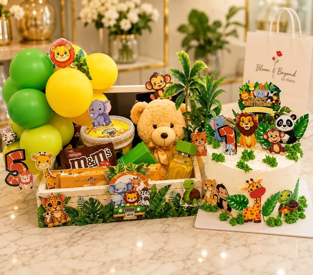 A full safari-themed children's birthday set: a wooden crate dressed with jungle-animal cutouts and foliage, holding a plush teddy — handcrafted by Bloom & Beyond in Lahore