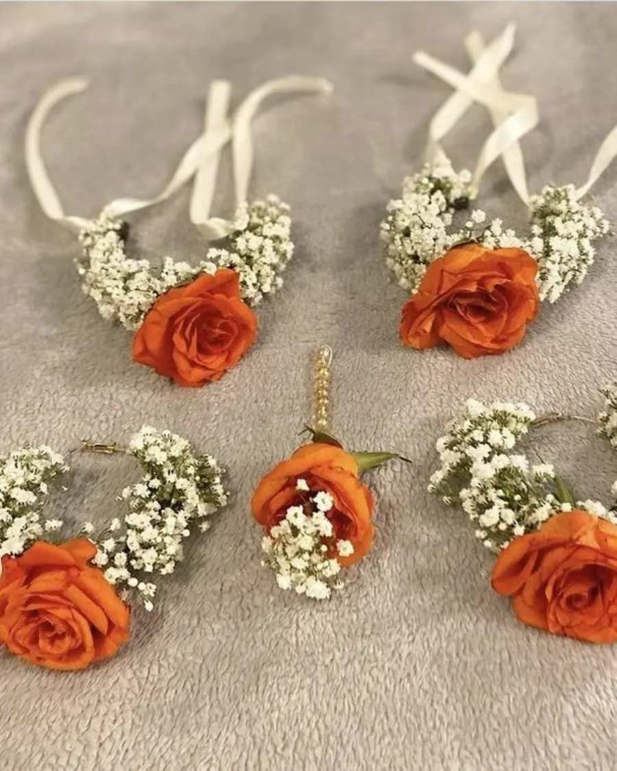 A set of three matching orange rose corsages with baby breath accents — handcrafted by Bloom & Beyond in Lahore