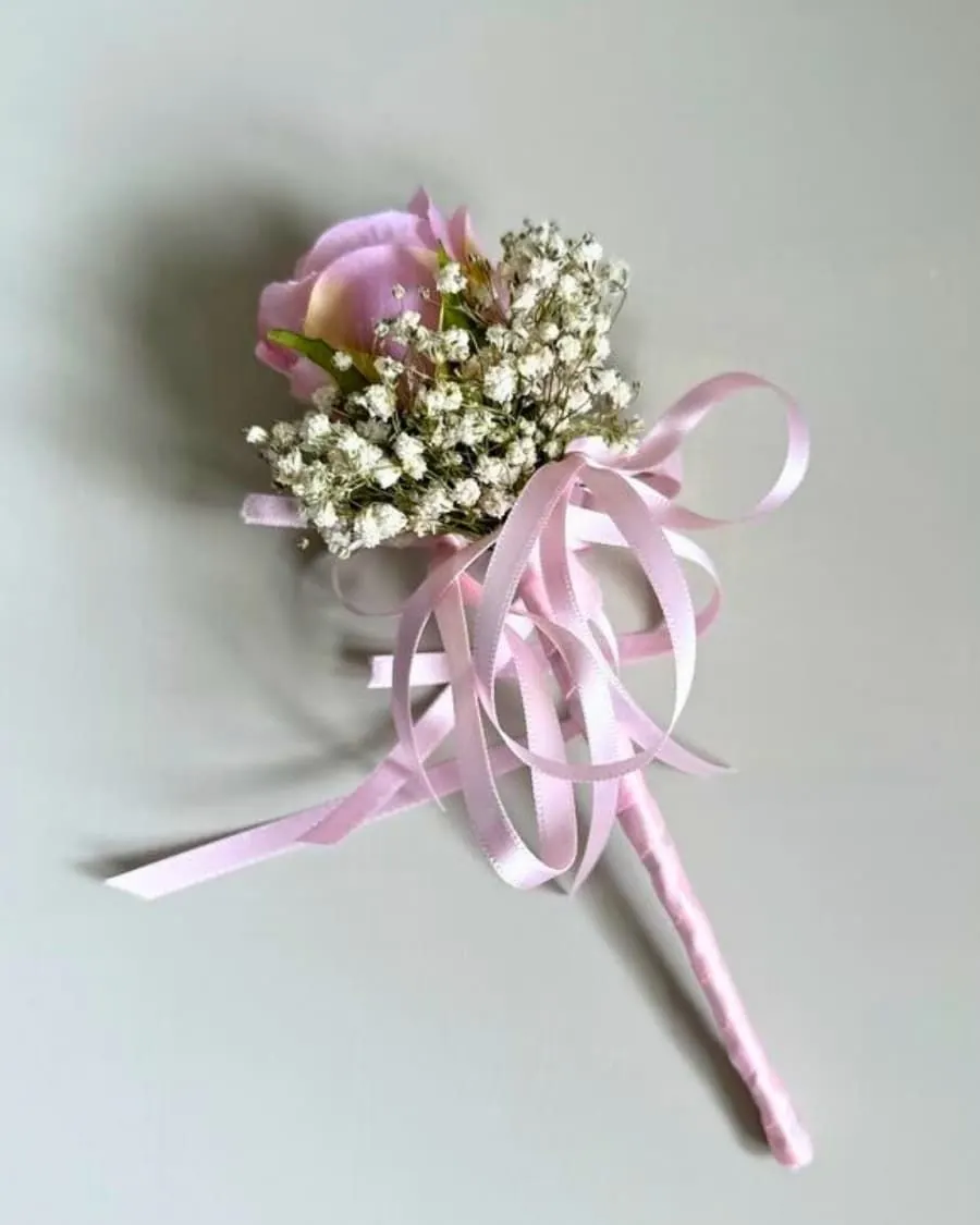 A fresh pink rose boutonniere with delicate baby breath and ribbon — handcrafted by Bloom & Beyond in Lahore