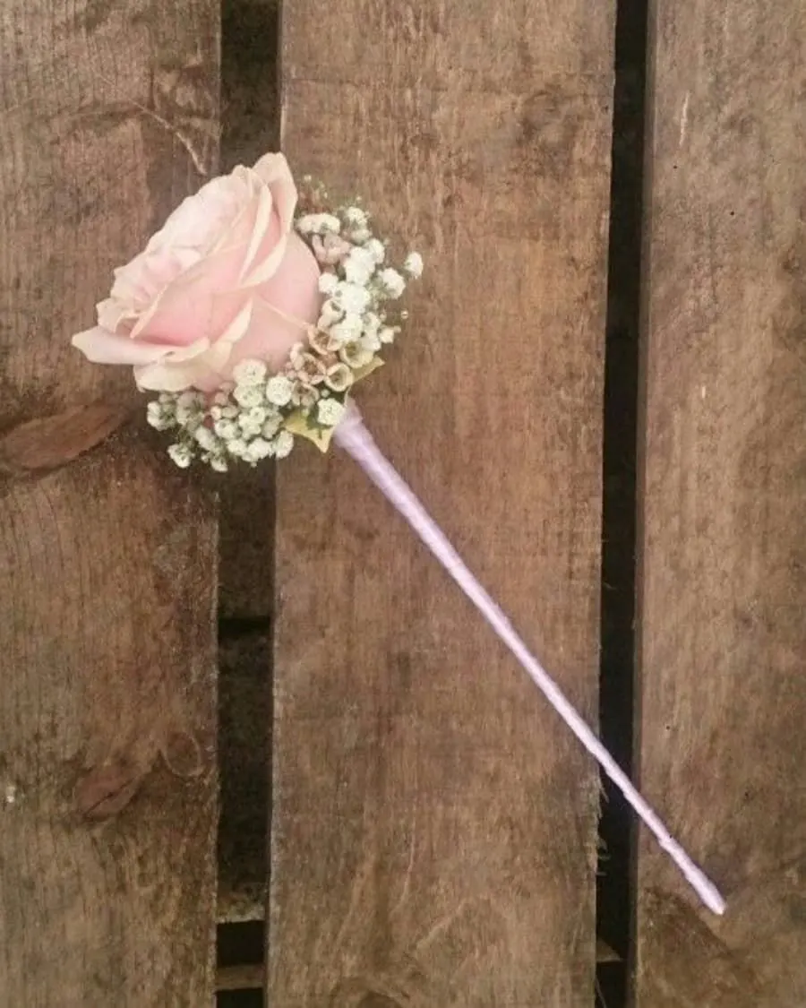 A single pink rose with baby breath on a ribbon-wrapped wand — handcrafted by Bloom & Beyond in Lahore