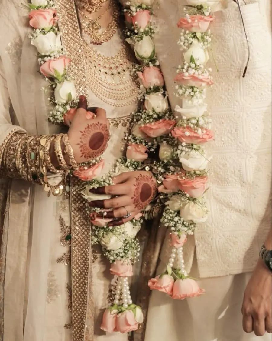 A matching pair of pink and white rose garlands with pearl accents for the bride and groom — handcrafted by Bloom & Beyond in Lahore