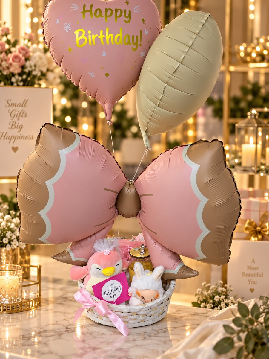 A Happy Birthday heart balloon and pink bow balloon above a basket of soft toys and treats — handcrafted by Bloom & Beyond in Lahore