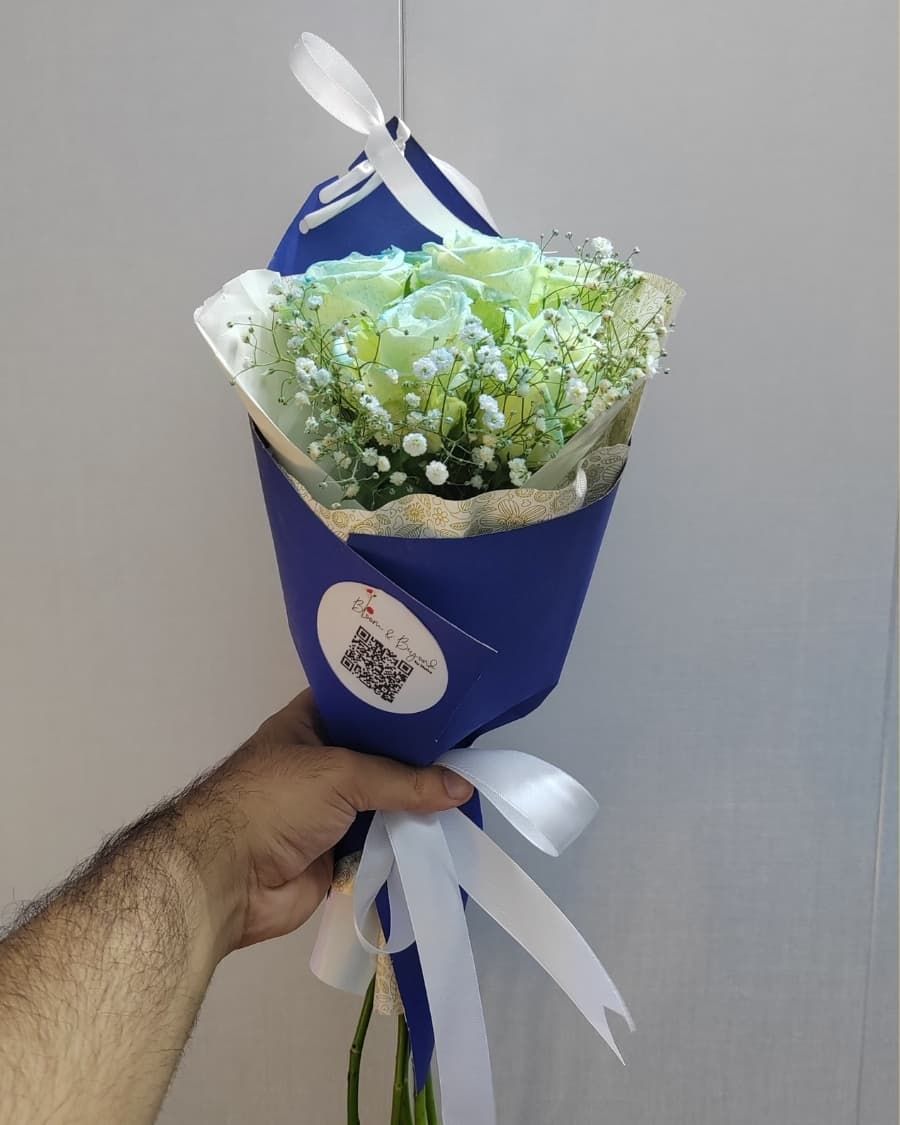 Rare tinted blue roses with baby breath in navy blue wrapping — a unique and memorable gift — handcrafted by Bloom & Beyond in Lahore