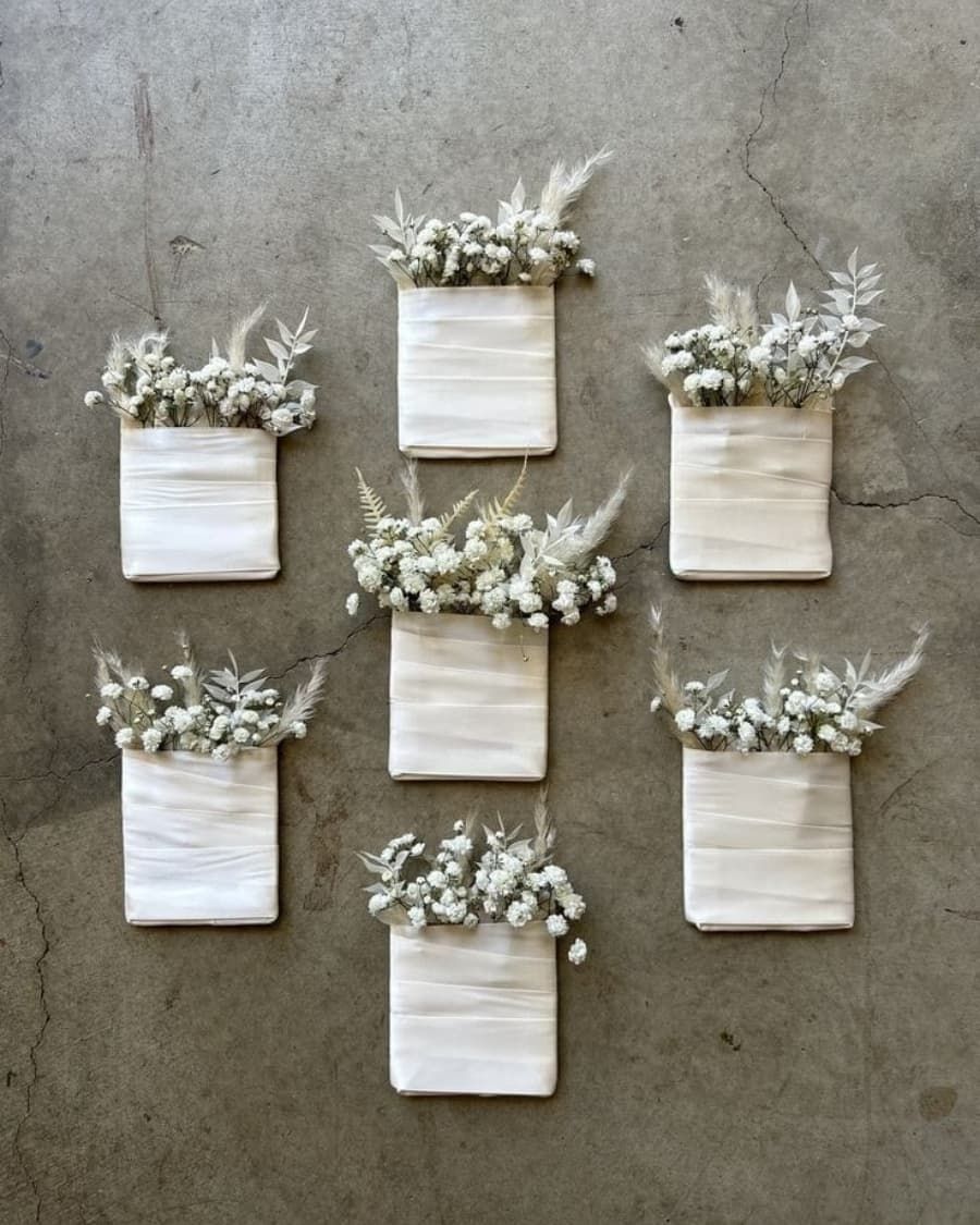 A set of three mini dried flower arrangements tucked in linen fabric pockets — handcrafted by Bloom & Beyond in Lahore