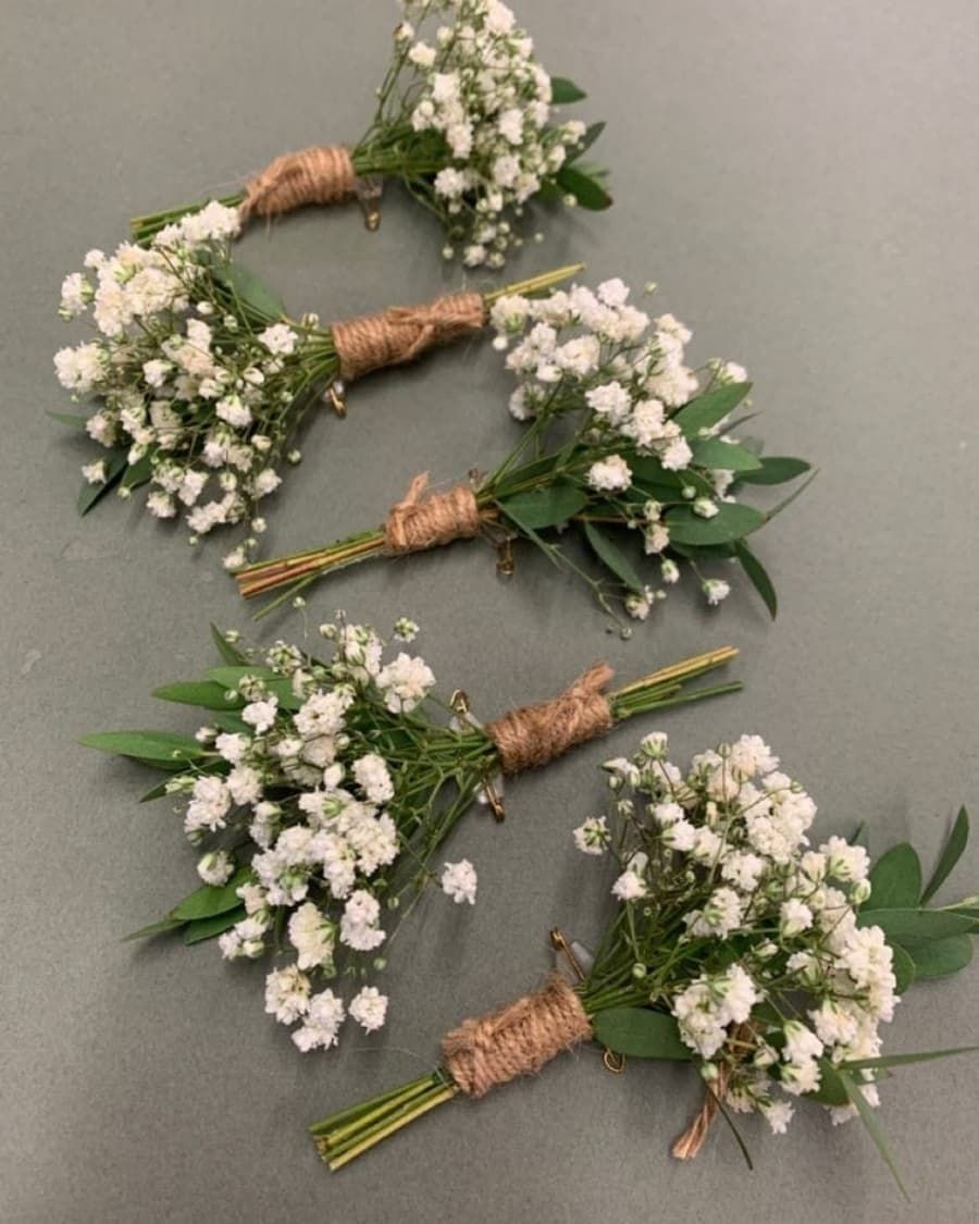 A set of five matching baby breath boutonnieres with twine wrapping — handcrafted by Bloom & Beyond in Lahore