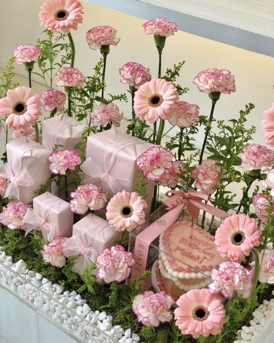 A grand floral display with pink gerberas, carnations, wrapped gifts, and a cake — handcrafted by Bloom & Beyond in Lahore