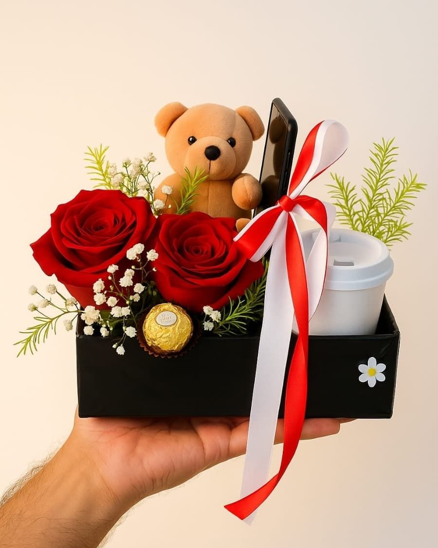 A compact love box with red roses, a cuddly teddy bear, Ferrero Rocher chocolates, and a coffee cup — all nestled in a decorated box — handcrafted by Bloom & Beyond in Lahore
