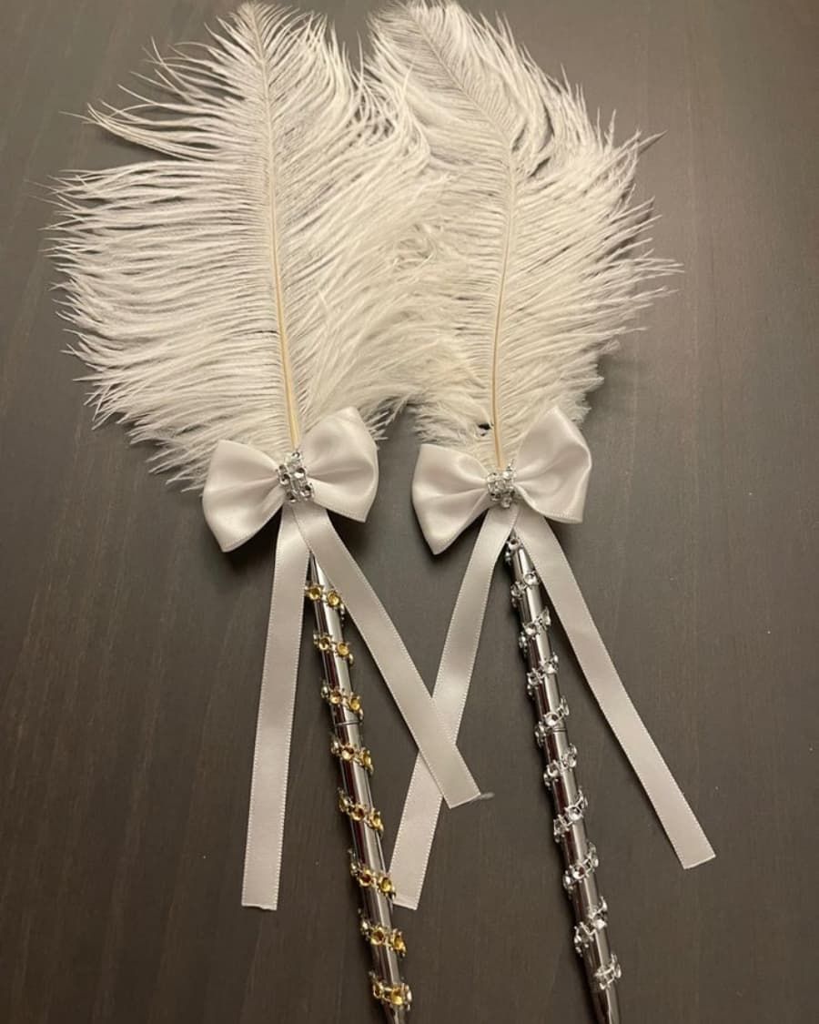 A pair of luxurious ostrich feather pens decorated with crystals and satin ribbons — one for the bride, one for the groom — handcrafted by Bloom & Beyond in Lahore