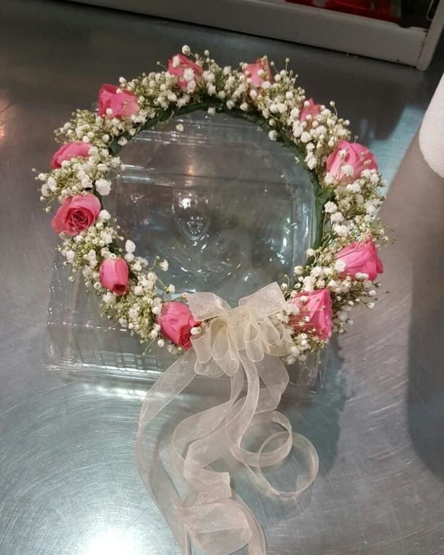 A romantic flower crown of pink roses and baby breath on a woven base — handcrafted by Bloom & Beyond in Lahore