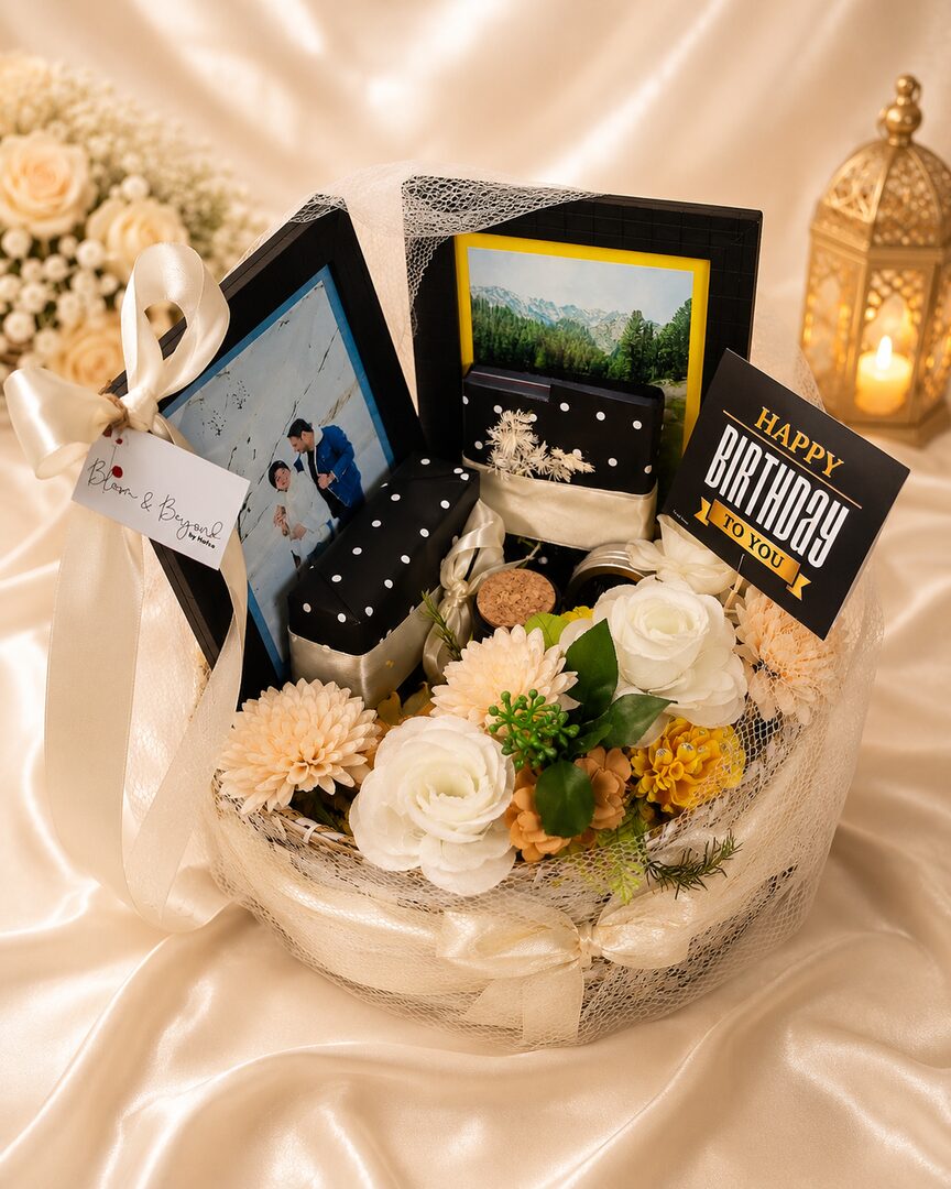 A premium basket built around two framed photos (a personal couple's photo plus a scenic print), a men's wallet — handcrafted by Bloom & Beyond in Lahore