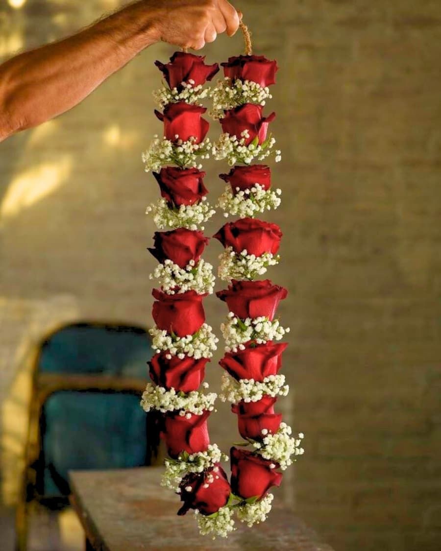 Red rose wedding haar — a fresh garland of red roses interspersed with baby's breath for the barat and rukhsati — handcrafted by Bloom & Beyond in Lahore