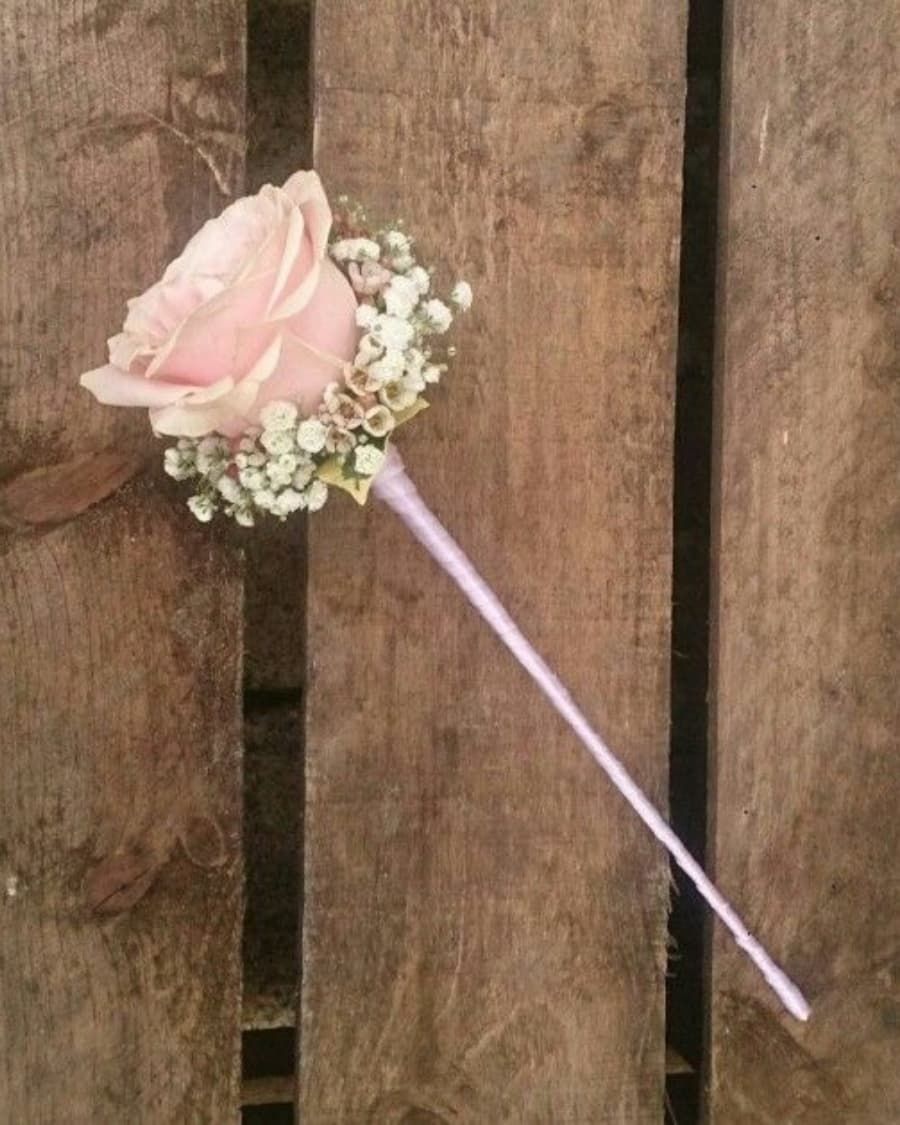 A single pink rose with baby breath on a ribbon-wrapped wand — handcrafted by Bloom & Beyond in Lahore