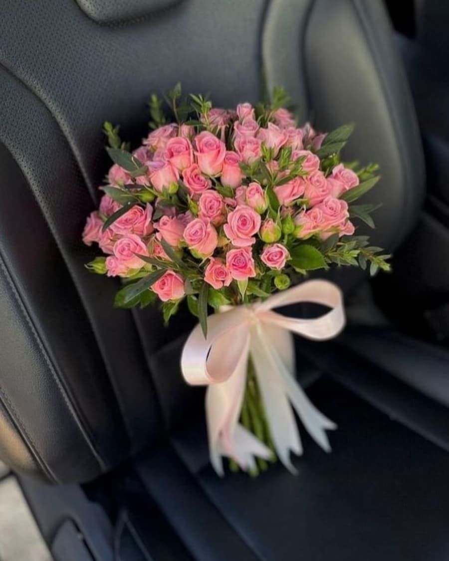 Clusters of delicate pink spray roses tied with a statement ribbon bow — handcrafted by Bloom & Beyond in Lahore
